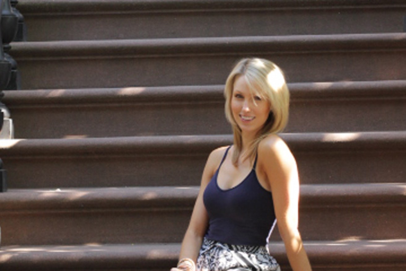 Lucy Travers on the stoop of a New York apartment block.