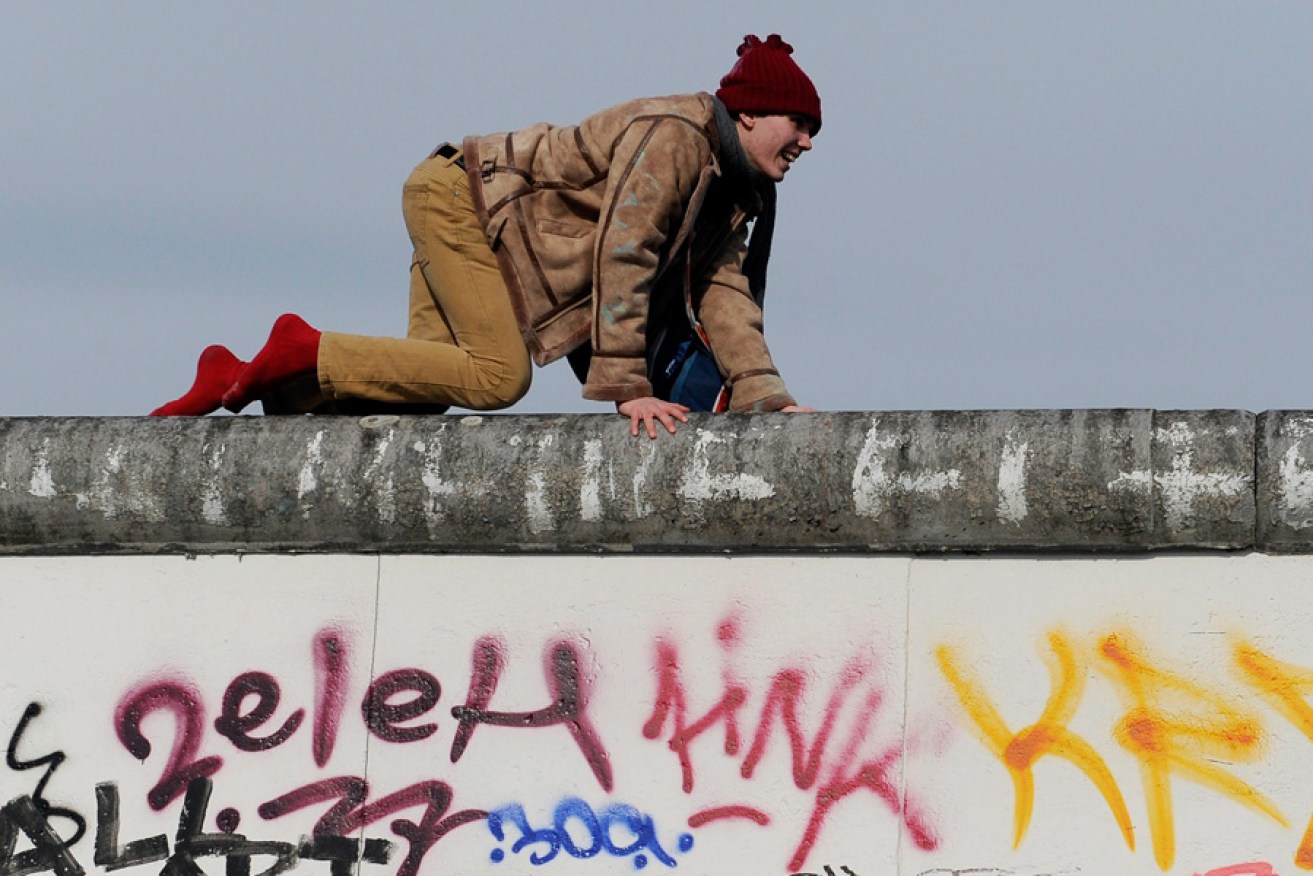 A demonstrator crawls on the East Side Gallery, a piece of art and part of the former Berlin Wall, in March this year. Protesters want to prevent the dislocation of parts of the memorial to make room for a building project.