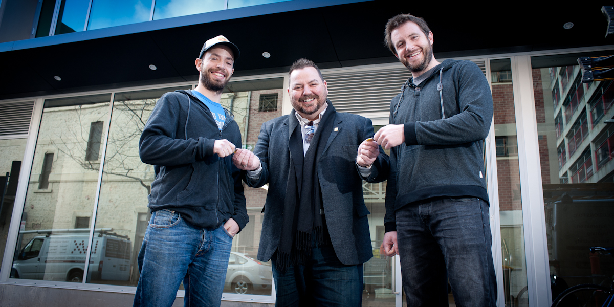 Burger Theory's Dan Mendelson and Rob Deans receiving the keys from developer Steve Maras (centre).
