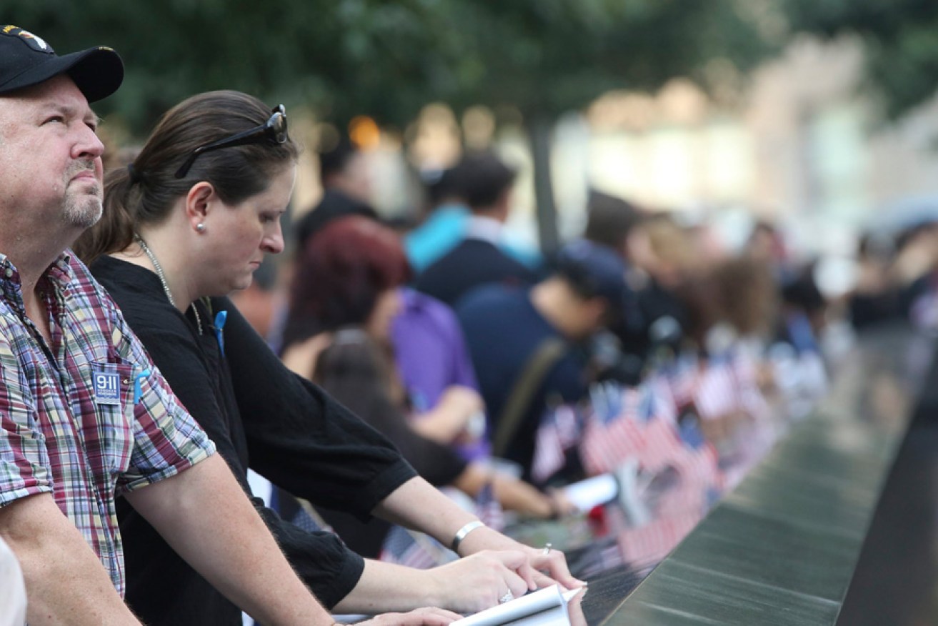 Mourners pause at the south reflection pool of the 9/11 Memorial during a ceremony marking the 12th anniversary of the 9/11 attacks on the World Trade Center in New York City.