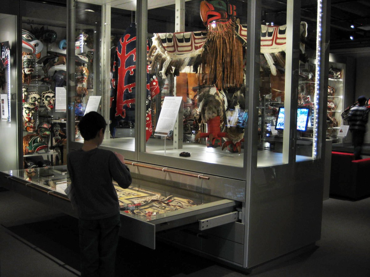 A child opening a drawer to view exhibits at the Multiversity Gallery, UBC Museum of Anthropology, in Vancouver, Canada. 