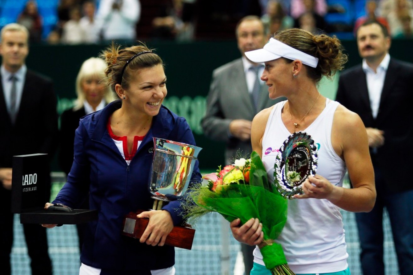 Simona Halep (L) of Romania holds her trophy after beating Samantha Stosur (R)