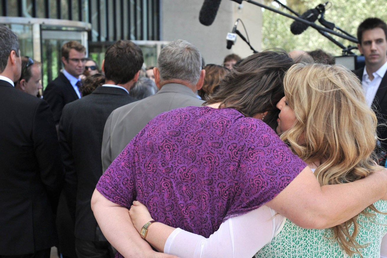A couple hug outside the High Court in Canberra yesterday.