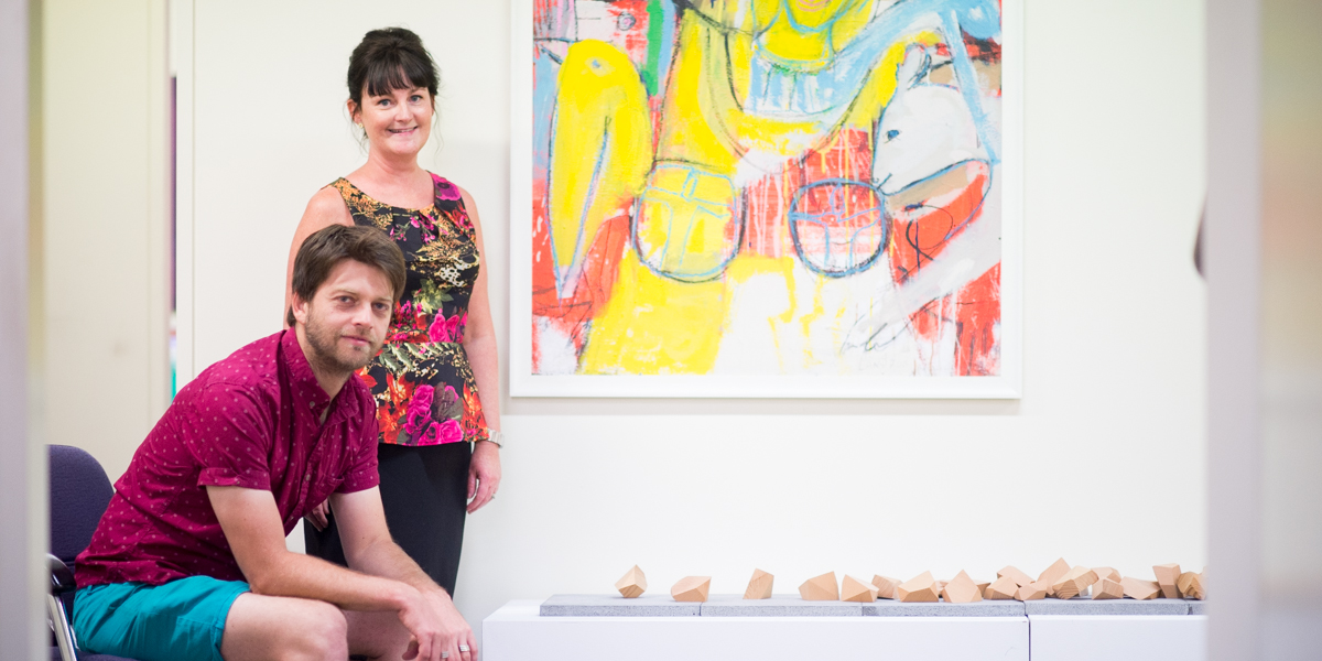 Carollyn Kavanagh and Tom Borgas alongside Borgas's Wooden Rocks and Stephen Langdon's acrylic painting Alice. Photo: Nat Rogers / InDaily