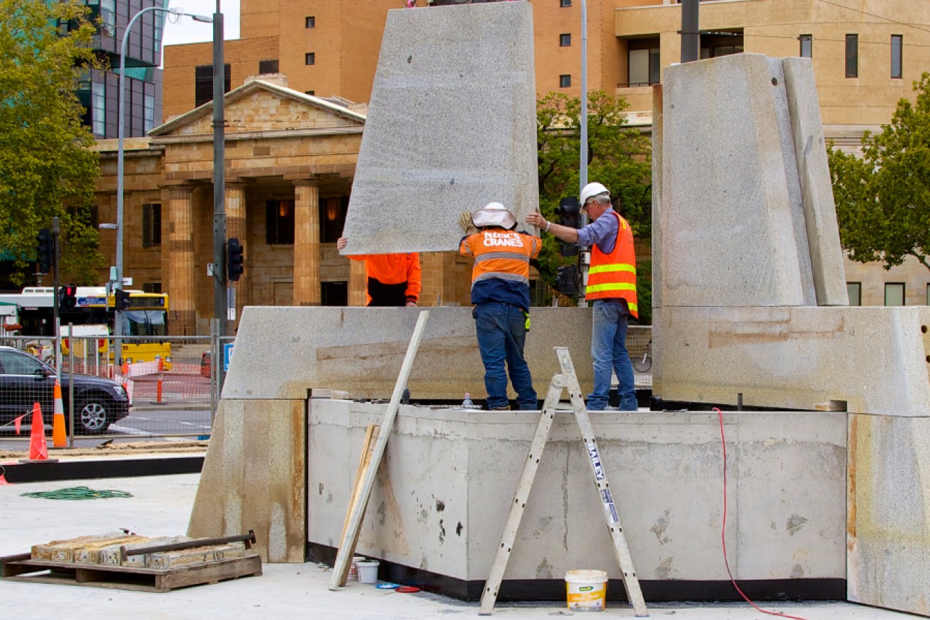 Workers reconstruct Three Rivers Fountain at Victoria Square's southern end.