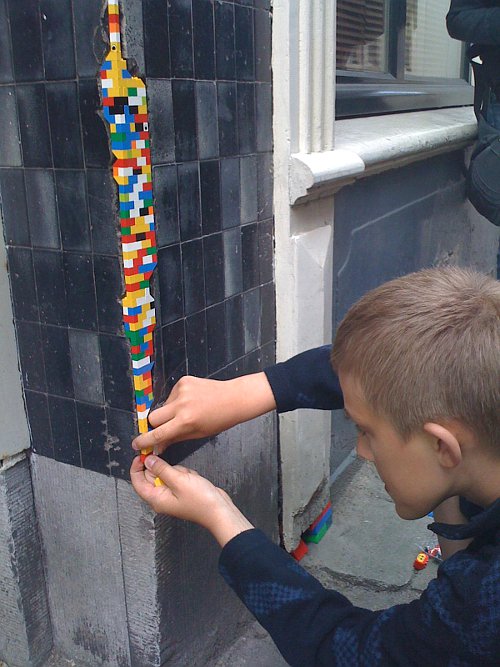 Jan Vormann travels the world repairing walls and buildings using Lego. Photo: Arne Hendriks, Flickr.