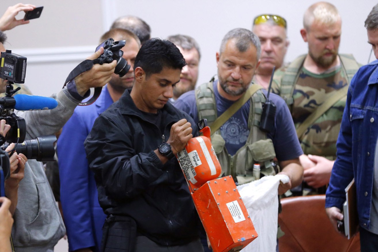 A Malaysian expert checks one of the two black boxes of MH17. Photo: EPA