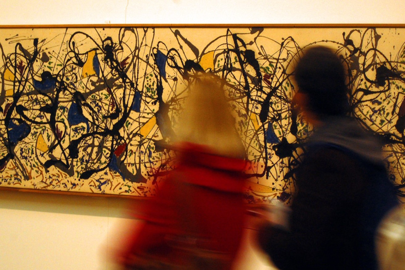 Gallery visitors examine a work by abstract artist Jackson Pollock in London's Tate Modern.