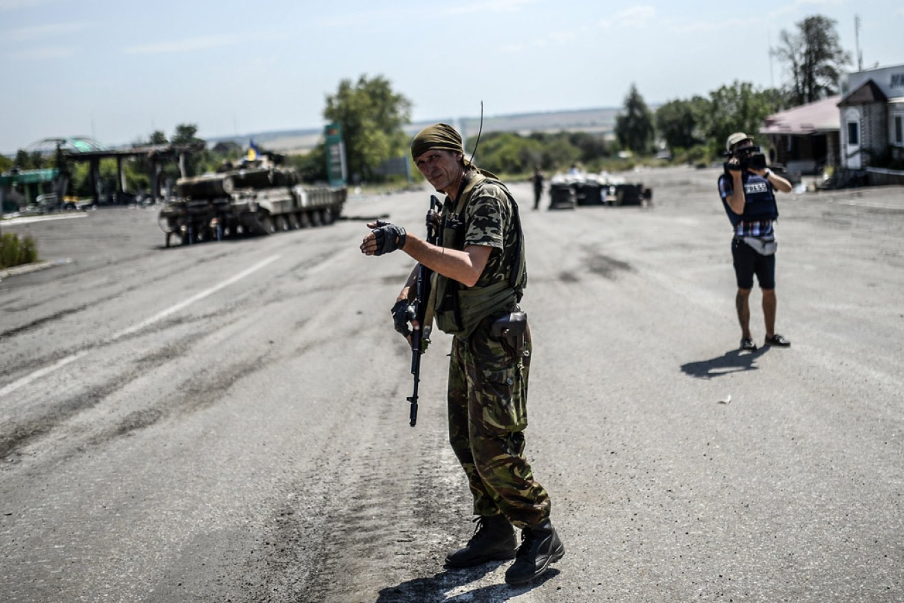 A Ukrainian soldier controls traffic at a check-point in eastern Ukraine. Photo: AFP