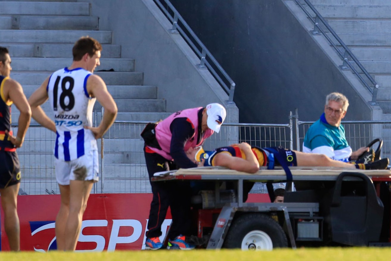 Down and out: Adelaide's Rory Laird leaves the field on a stretcher during Saturday's game. 