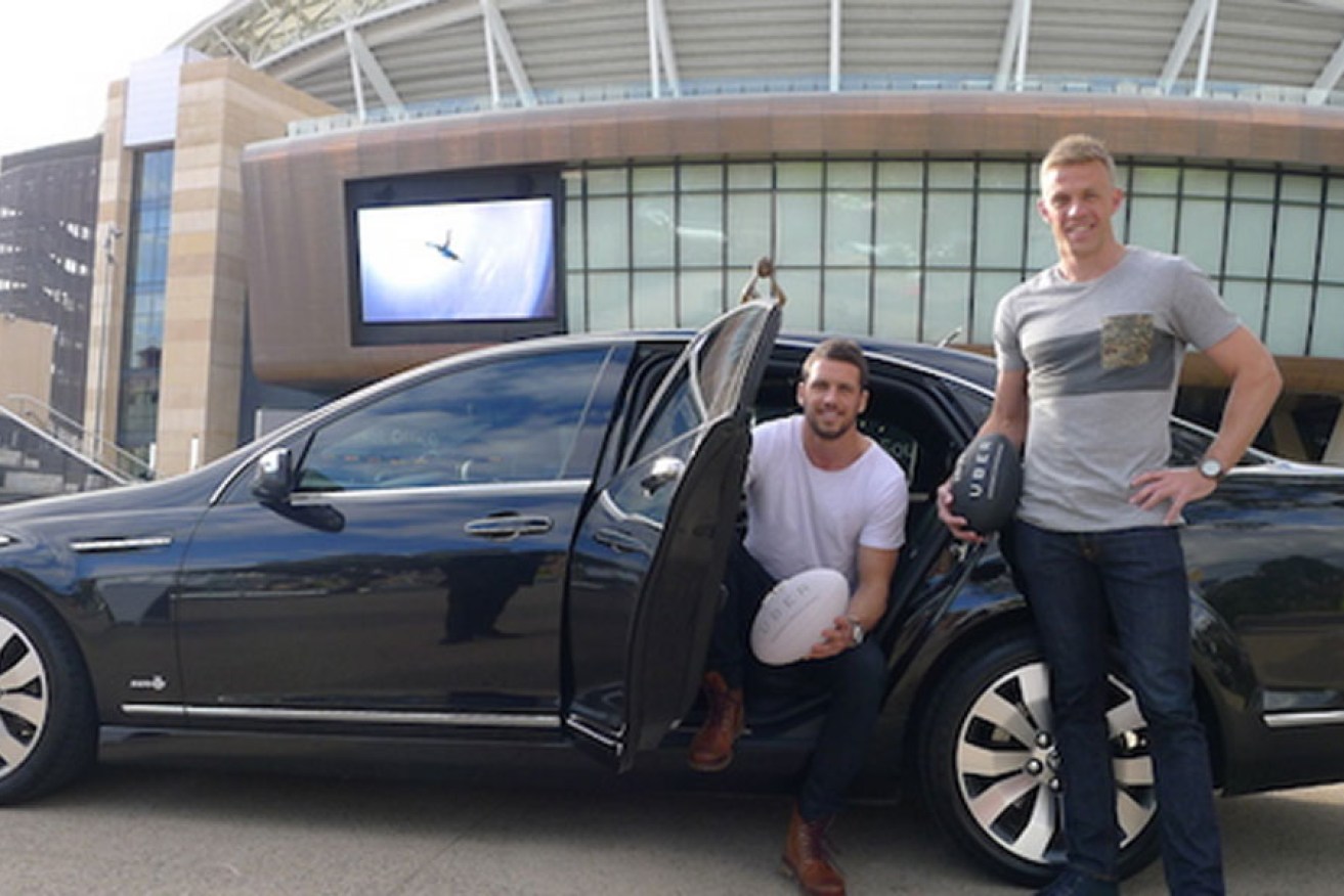 Port Adelaide captain Travis Boak and Crows' skipper Nathan van Berlo in an Uber promotion.
