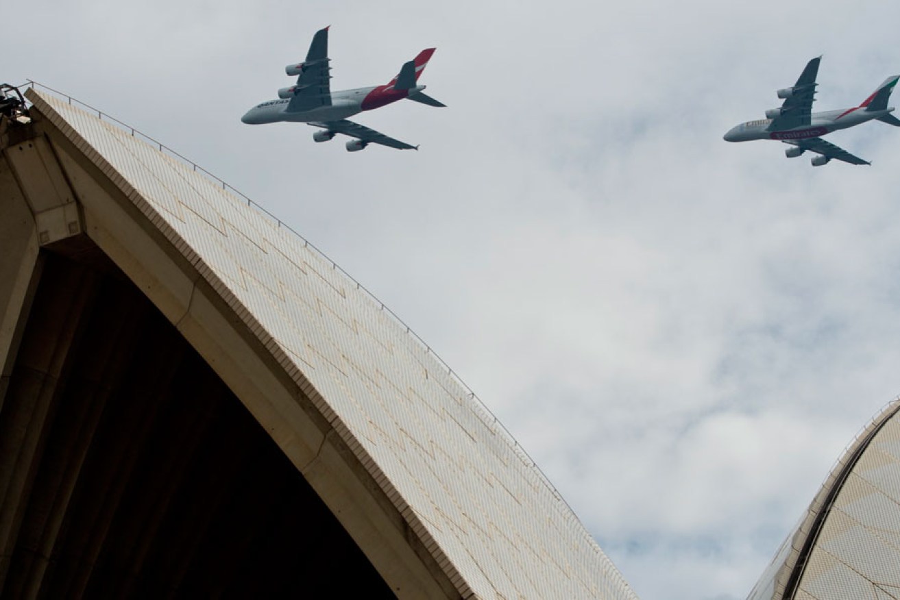 A Qantas A380 (left) and an Emirates A380 perform a fly-over at 1500 feet over Sydney Opera House to mark the partnership between the airlines.