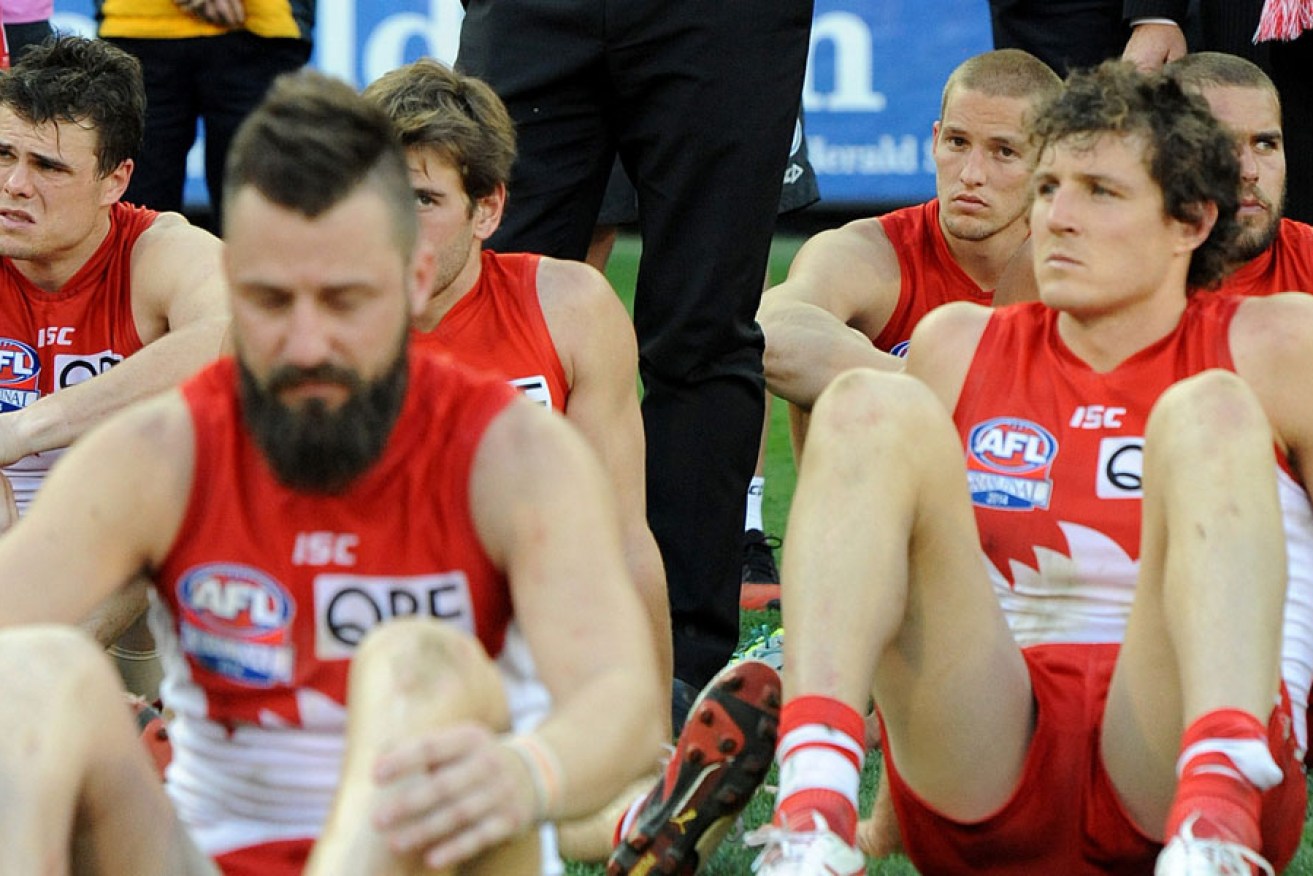 The Footballer-Formerly-Known-as-He-Who-Shall-Not-Be-Named (right) with other miserable Swans after the grand final.