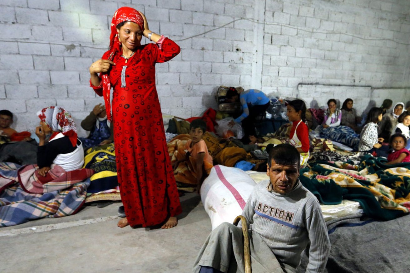 Syrian refugees sleep in the ruins of a house near the Turkish-Syrian border after fleeing Syria.