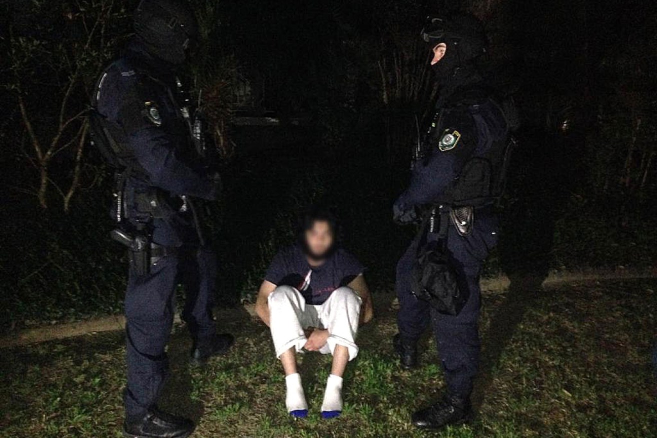 A man arrested following the execution of search warrants across Sydney's north-west suburbs, Thursday, Sept. 18, 2014. 