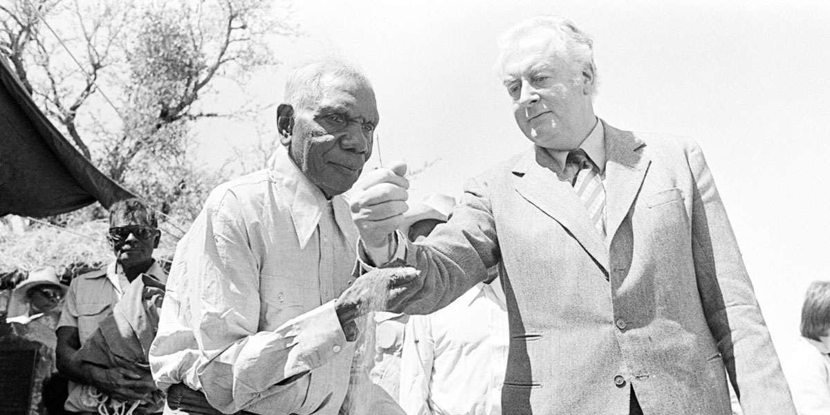 Whitlam with Aboriginal leader Vincent Lingiari in 1975. The pouring of the sand indicates the handing back of land to the Gurindji people. 