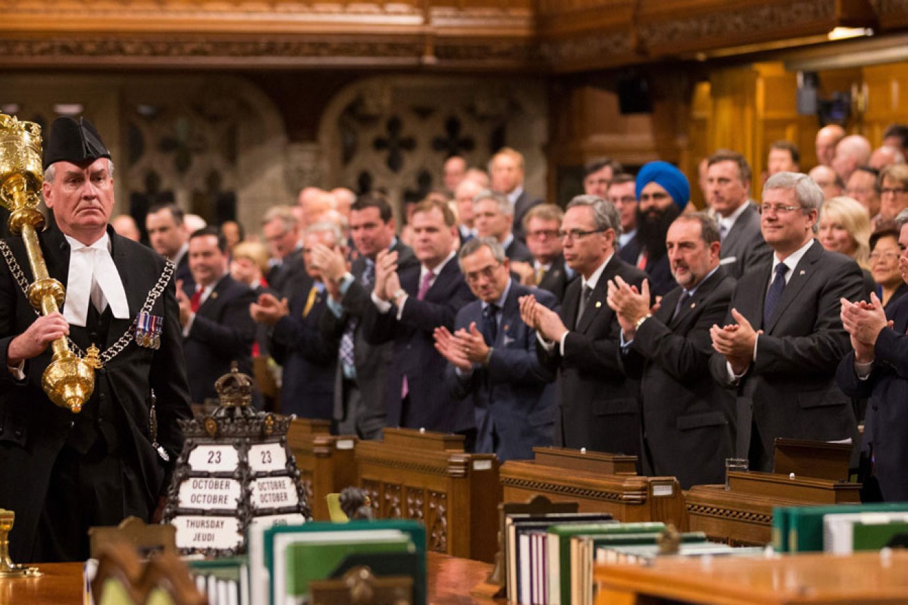 Members of the Canadian Parliament applaud Kevin Vickers, Sergeant-at-Arms.