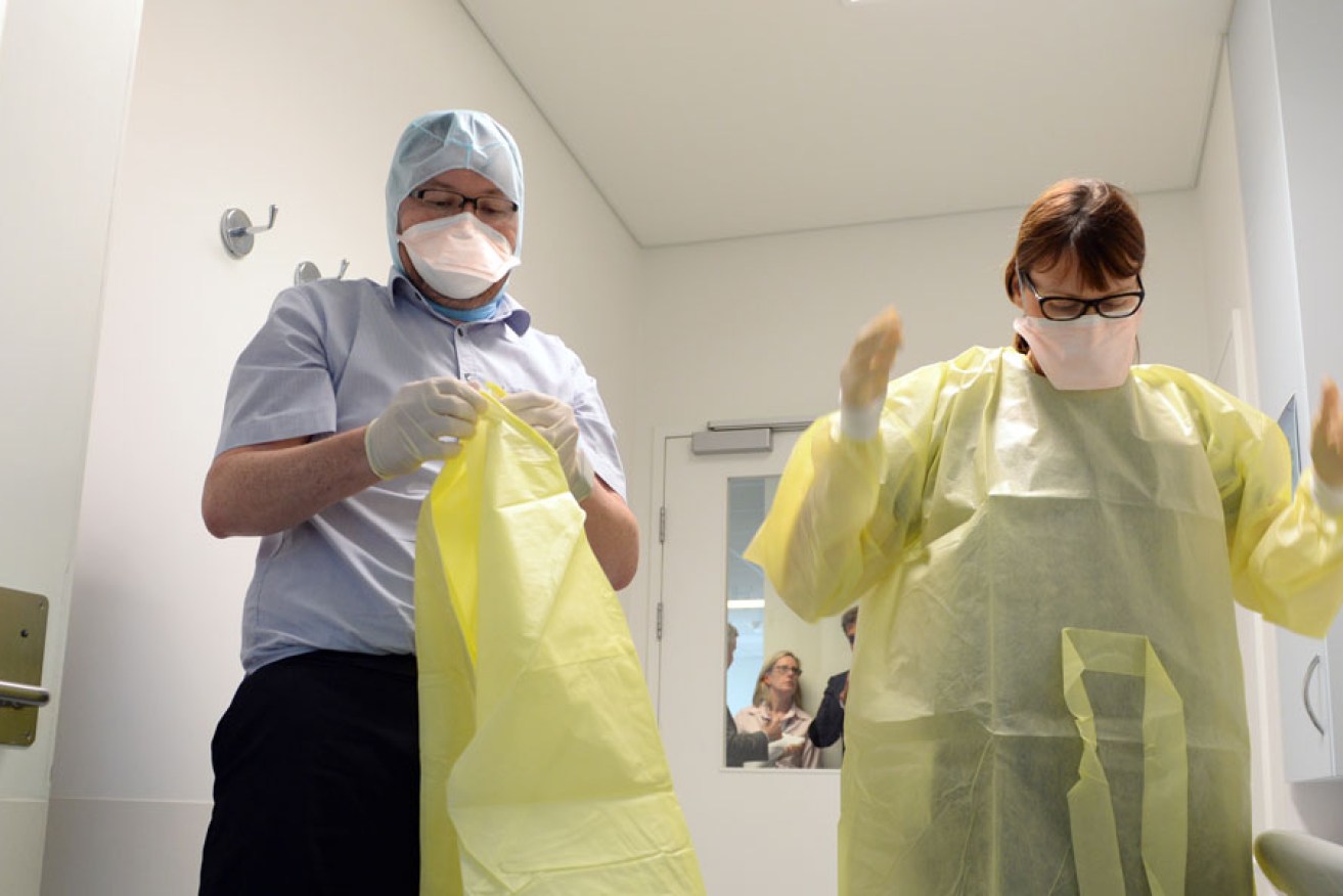 Nurses put on protective gear in the infectious diseases unit at the Royal Brisbane Hospital in Brisbane.