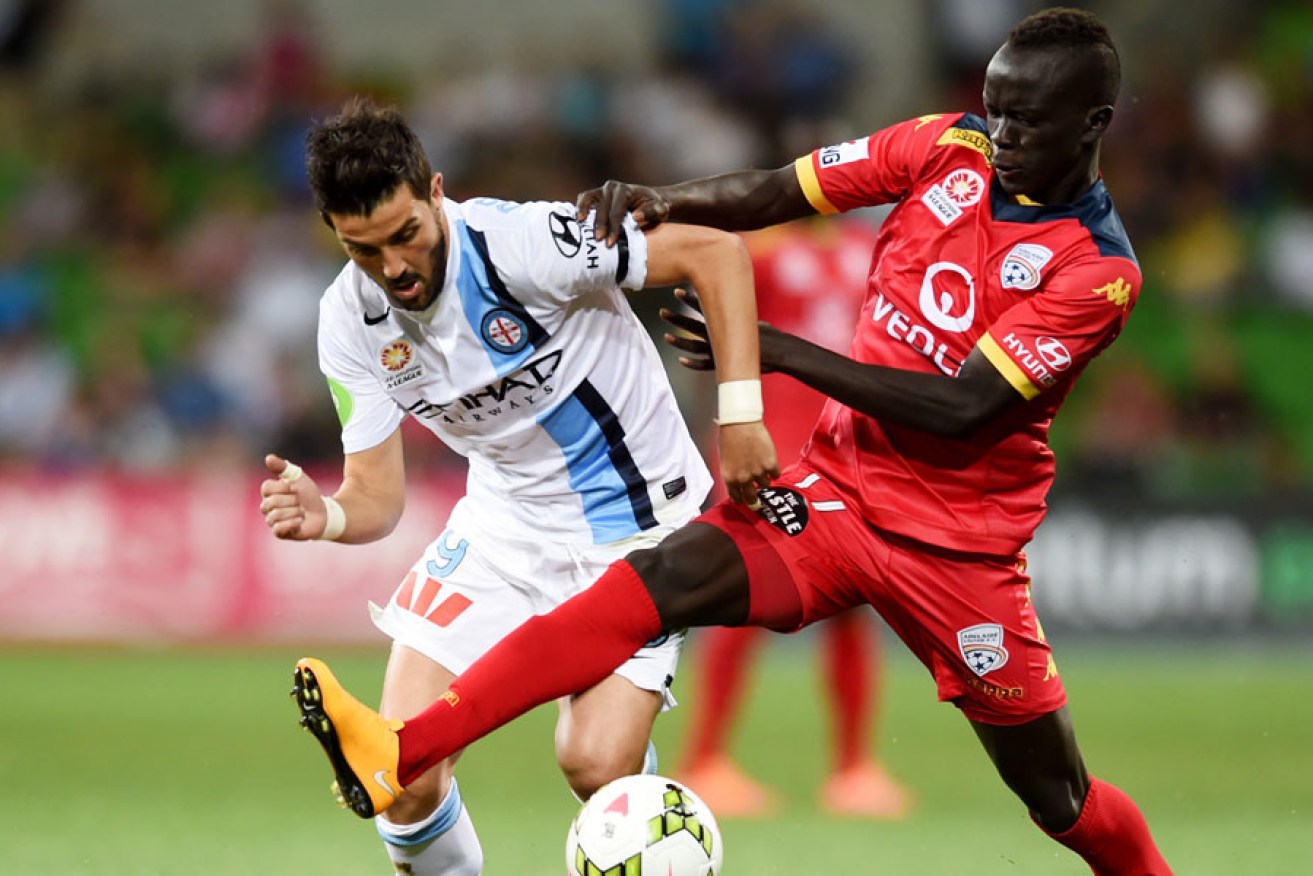 Melbourne City's on-loan star David Villa is tackled by Reds' young gun Awer Mabil during Friday night's game.