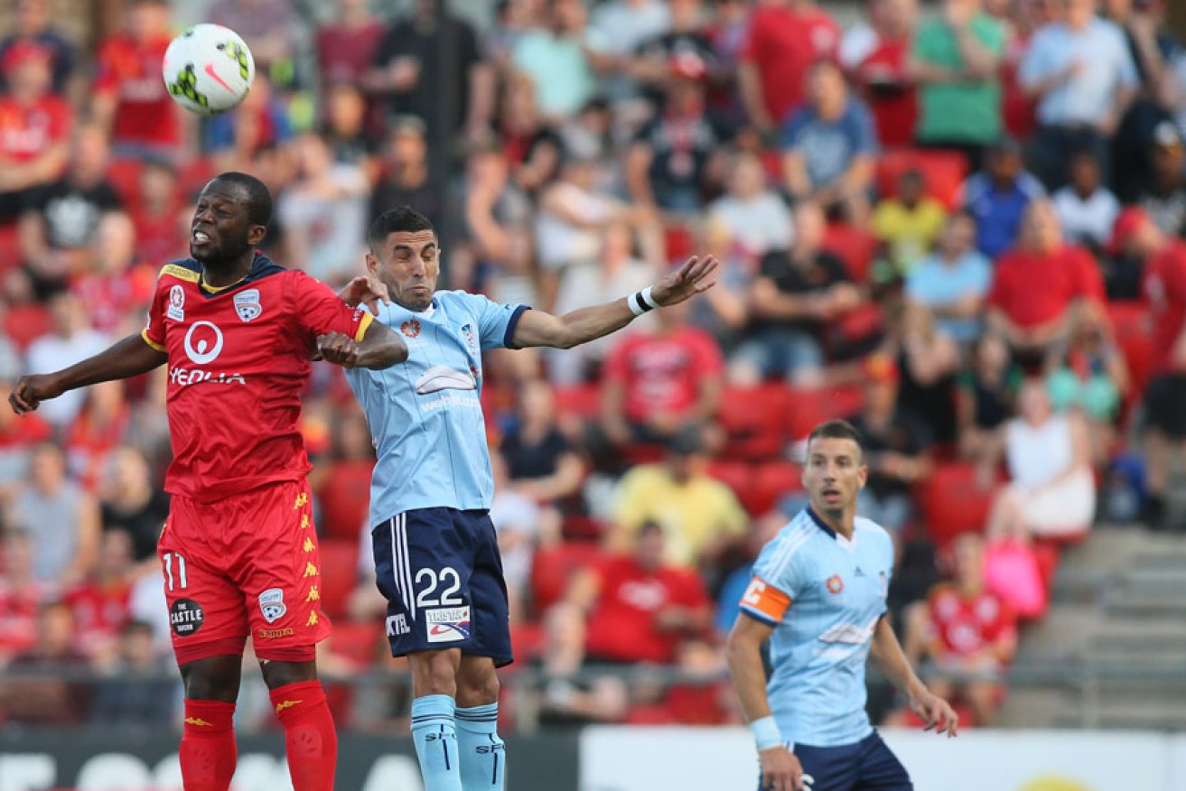 Reds' danger man Bruce Djite jumps for a header before coming off injured against Sydney FC.