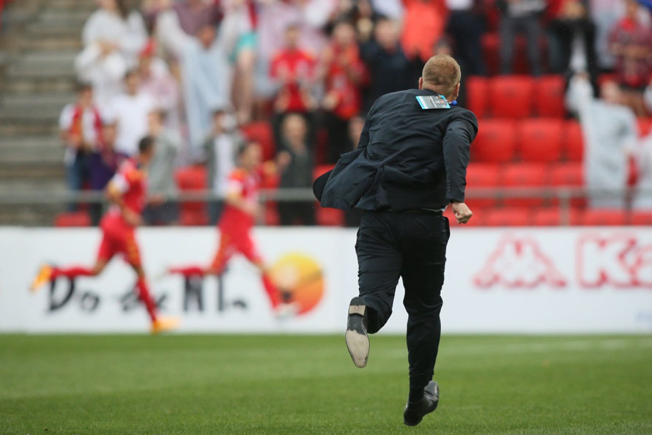 Reds coach Josep Gombau races onto the field to congratulate his team after they scored the winning goal to defeat Wellington Phoenix.