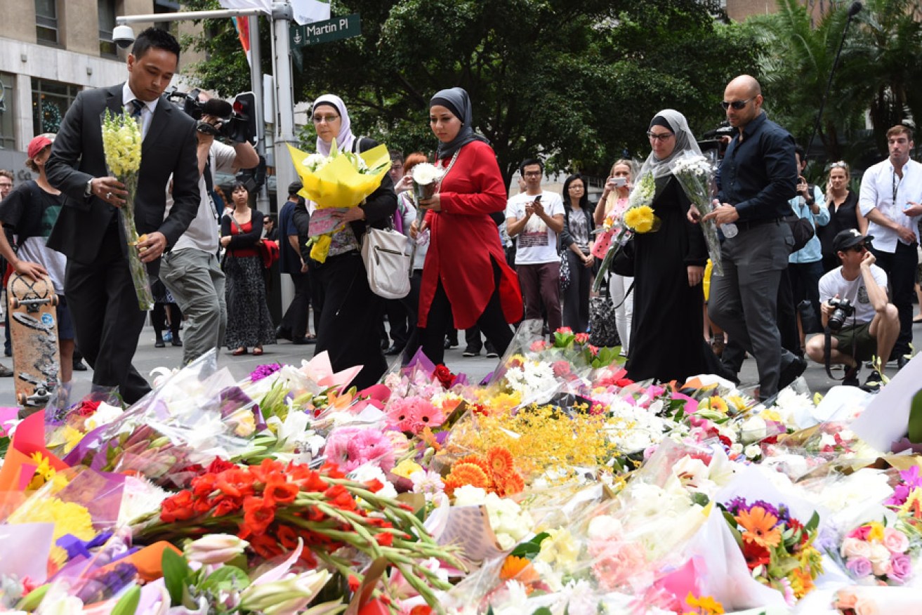 Muslim community members lay flowers near the Lindt chocolate cafe in Martin Place following the siege. Photo: AAP 