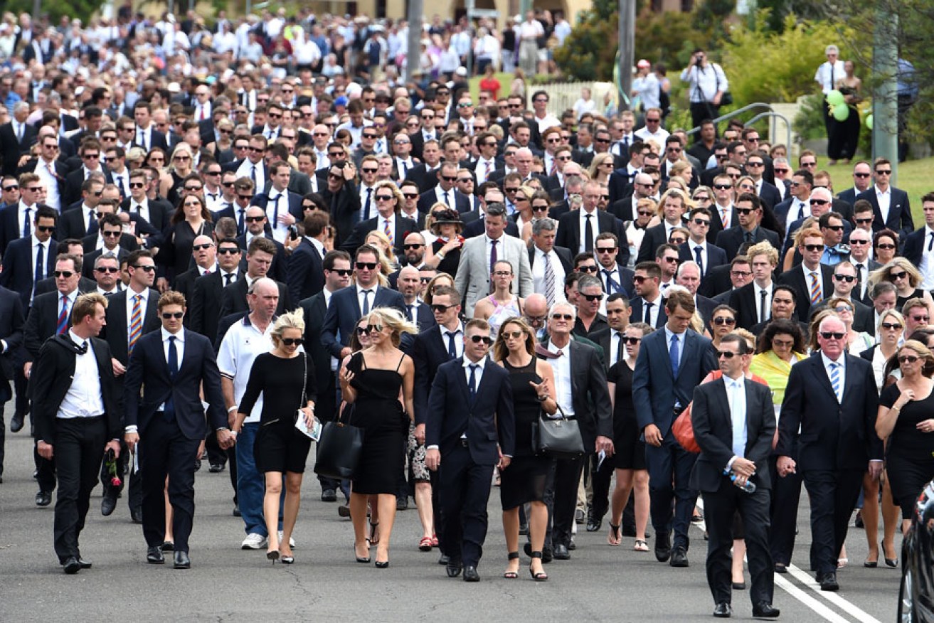 Mourners, including many past and present Australian cricketers, walk down Wallace St, Macksville, after Phillip Hughes' funeral.