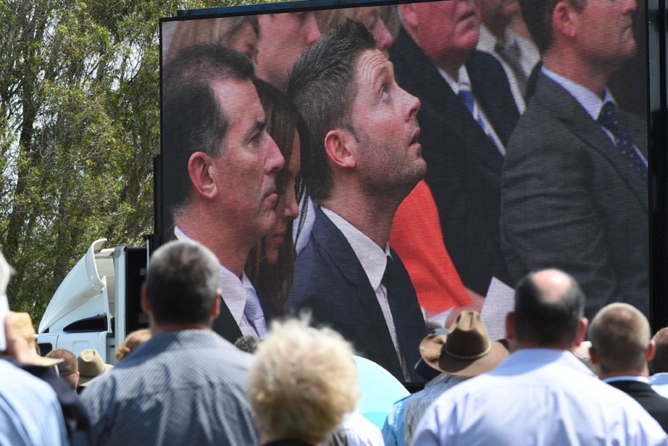 Test captain Michael Clarke on the big screen, as mourners watch Phillip Hughes' funeral in his home town of Macksville.