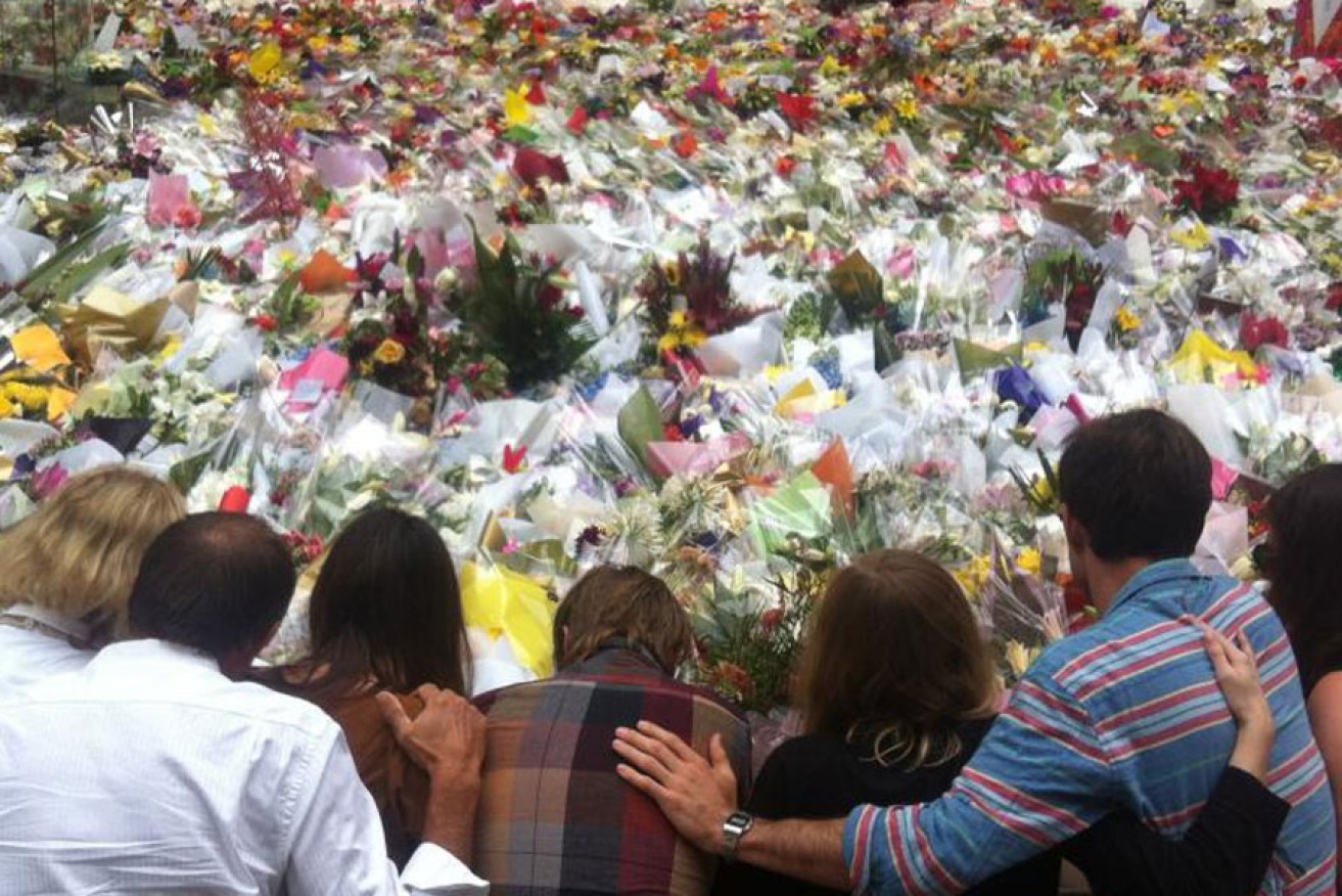 Mourners gather at the ever-growing floral tribute in Martin Place.