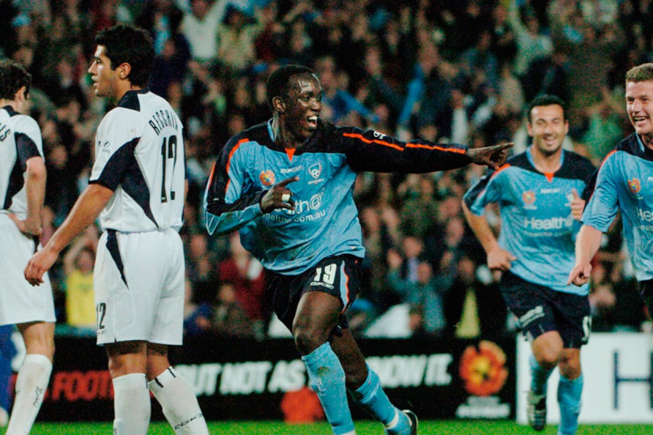 Dwight Yorke (centre) celebrates his first goal against Melbourne Victory in 2005.
