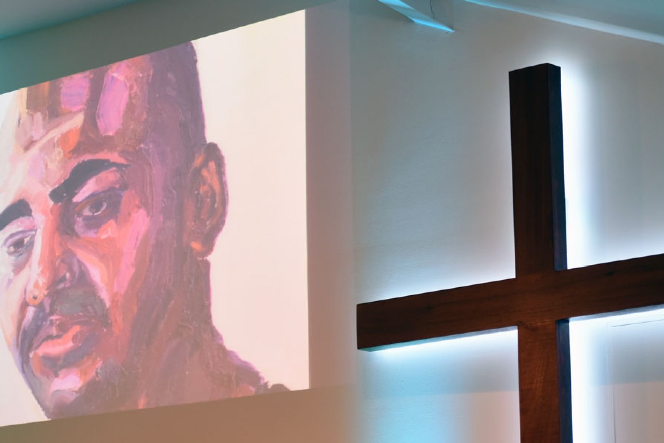 A self portrait of Myuran Sukumaran is projected onto the wall at a vigil for Sukumaran and Andrew Chan at the C3 church in Sydney.