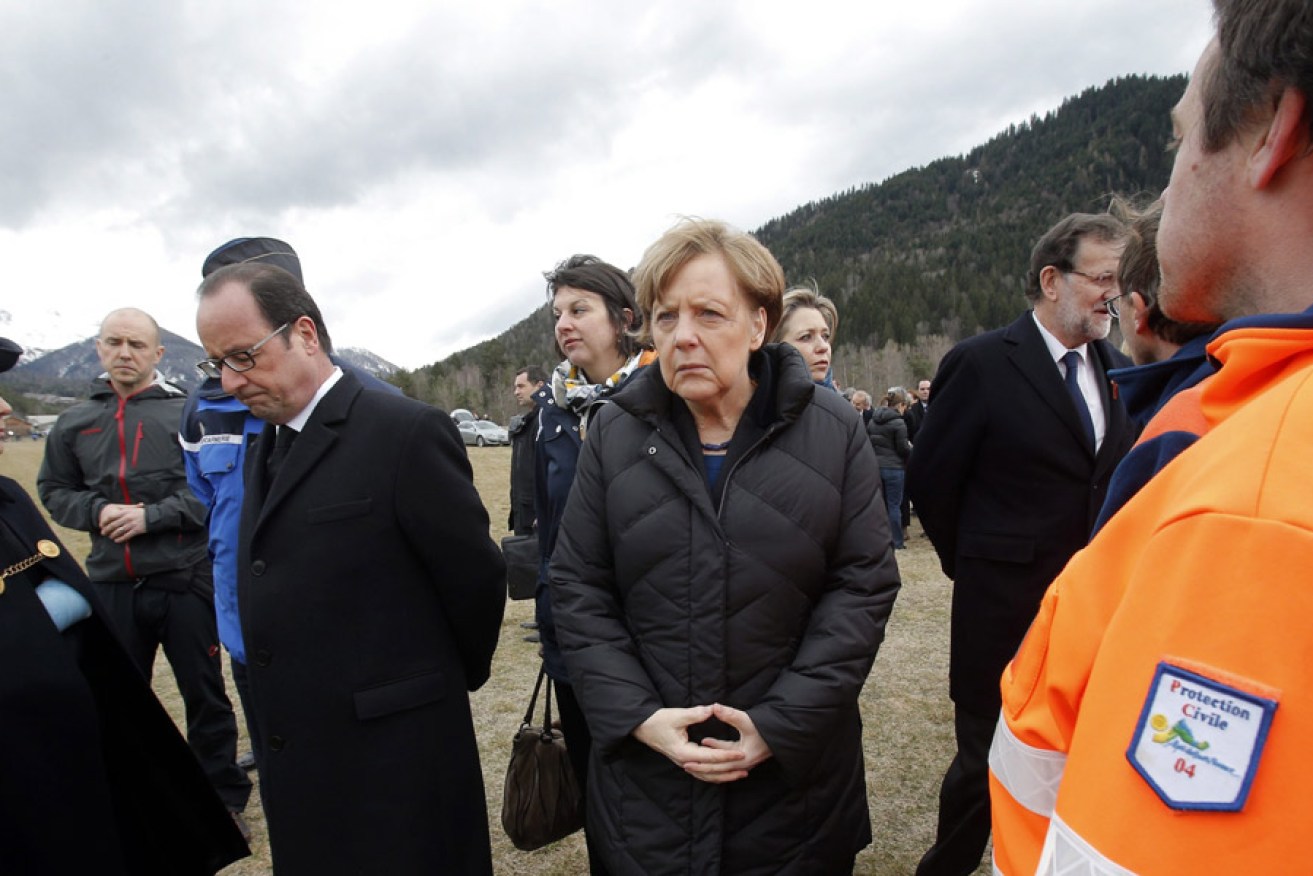French President Francois Hollande, German Chancellor Angela Merkel and Spanish Prime Minister Mariano Rajoy speak with rescue workers at the crash site. Photo: AAP