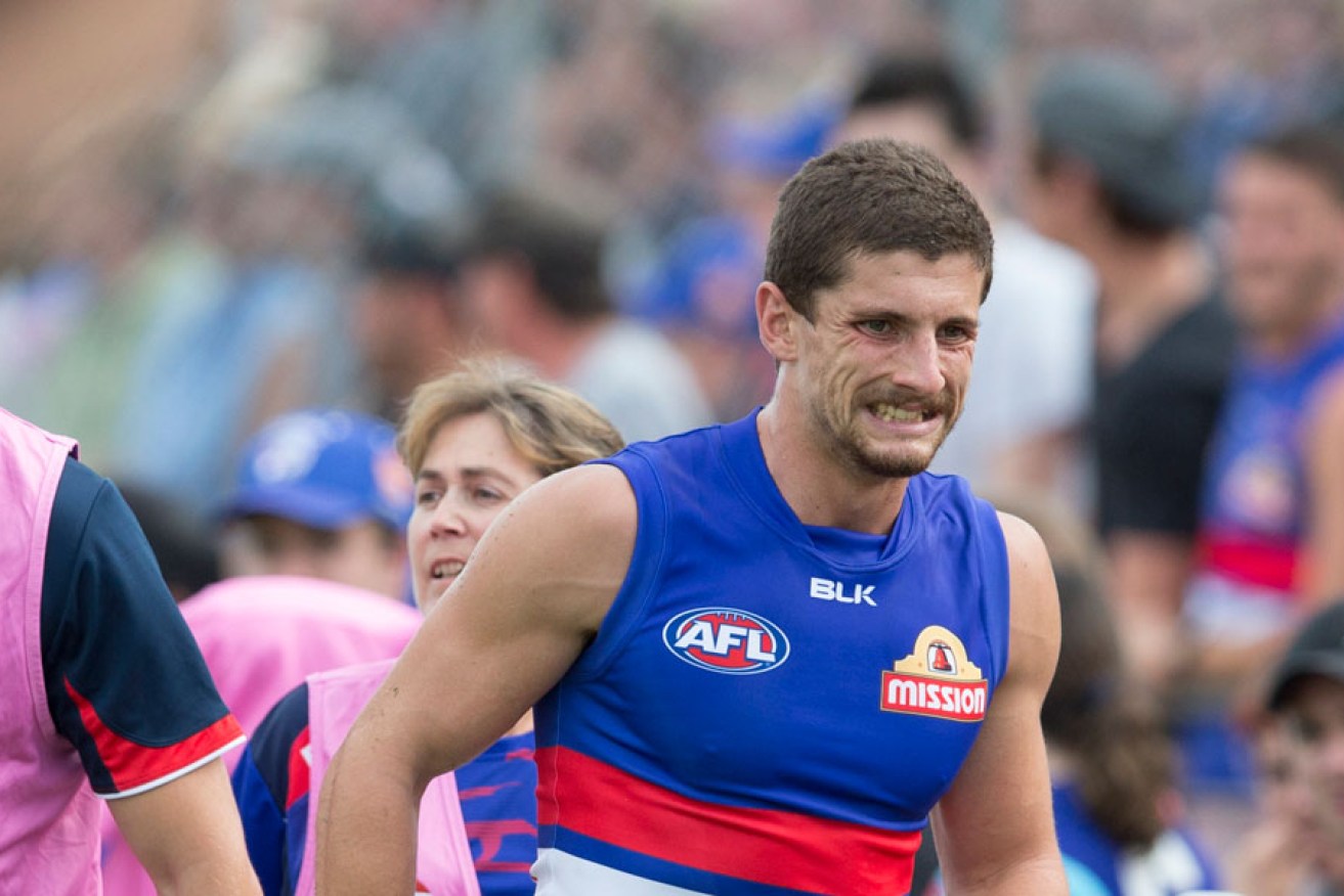 Tom Liberatore winces in pain after injuring his knee against Richmond.