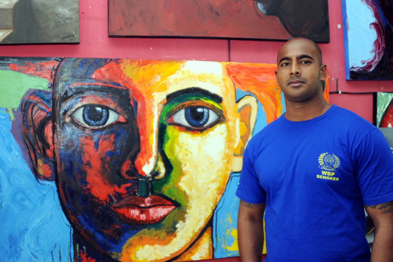 Condemned Australian drug smuggler Myuran Sukumaran stands in front of his paintings in Kerobokan prison.