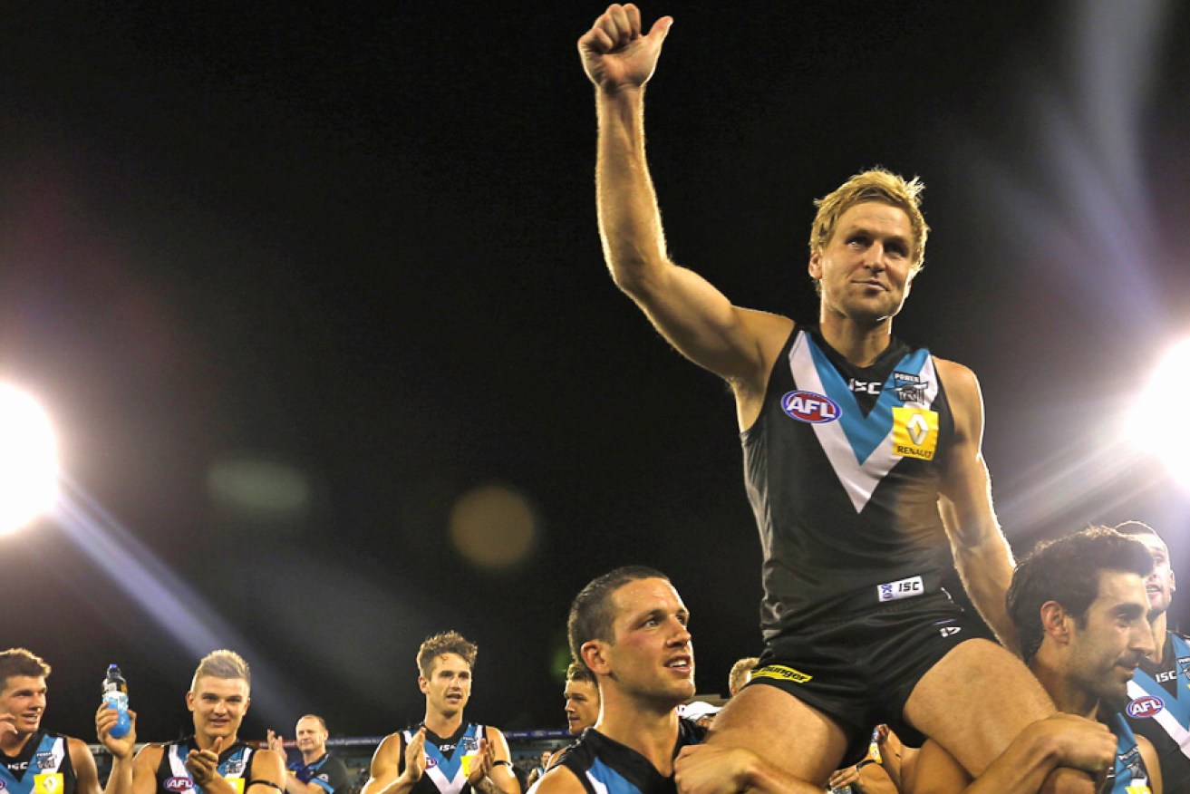 Cornes celebrating his 250th game in 2013. AAP photo