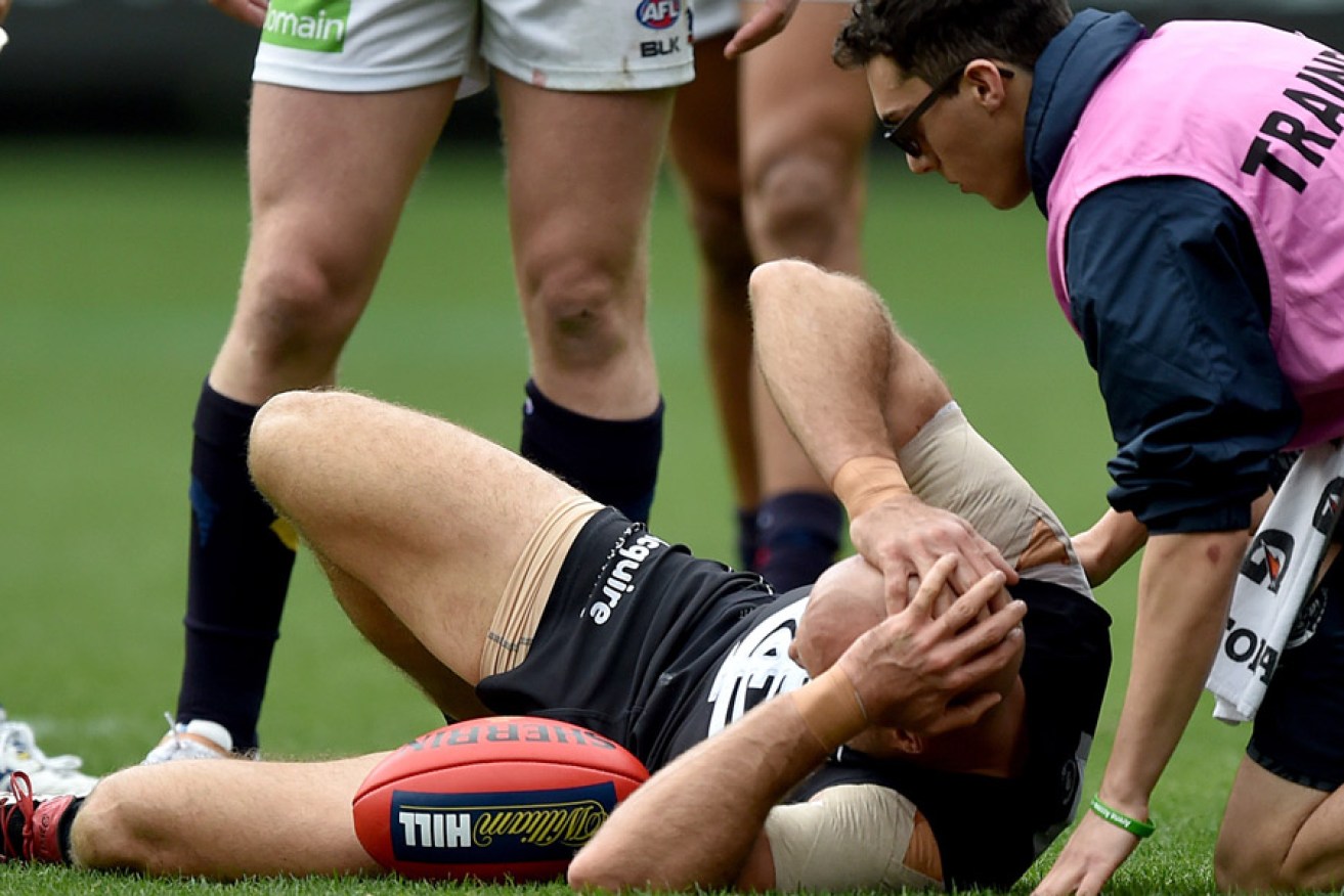 Chris Judd lies on the ground after injuring his knee during Saturday's match. Photo: AAP