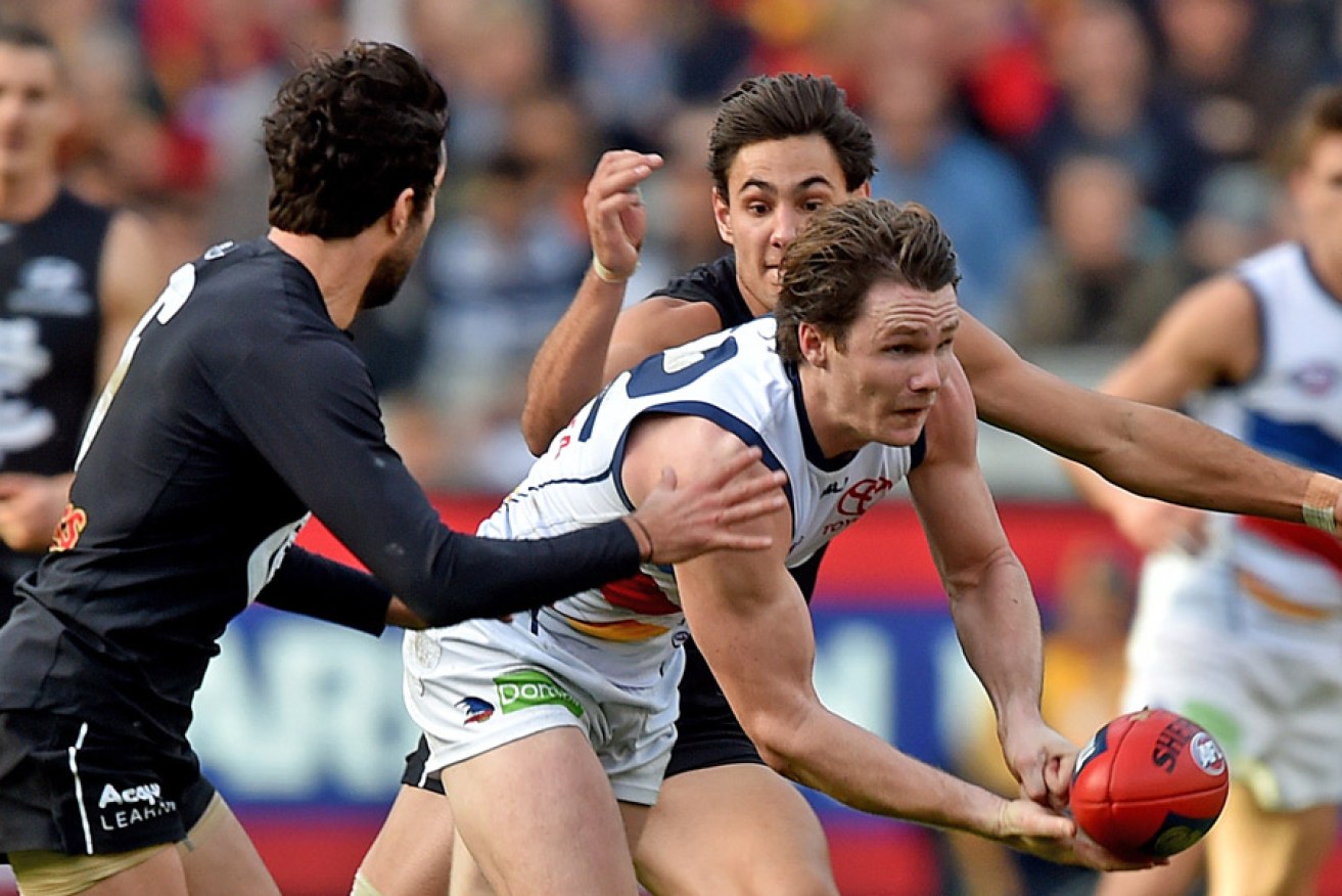 Patrick Dangerfield of the Crows beats a tackle by Kade Simpson and Troy Menzel of the Blues, during the round 10 AFL match. Photo: AAP