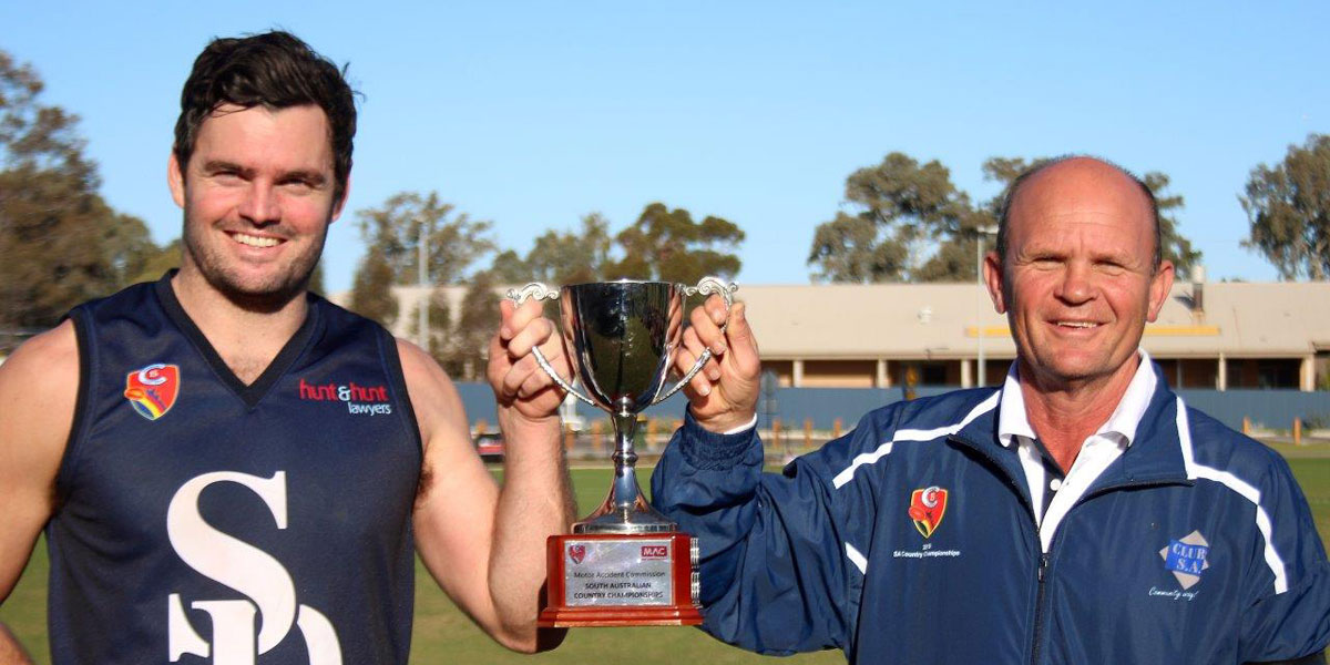 Southern Districts captain Tarquin Brown (Victor Harbor) and coach Barry Pilmore lift the SA country championship cup. 