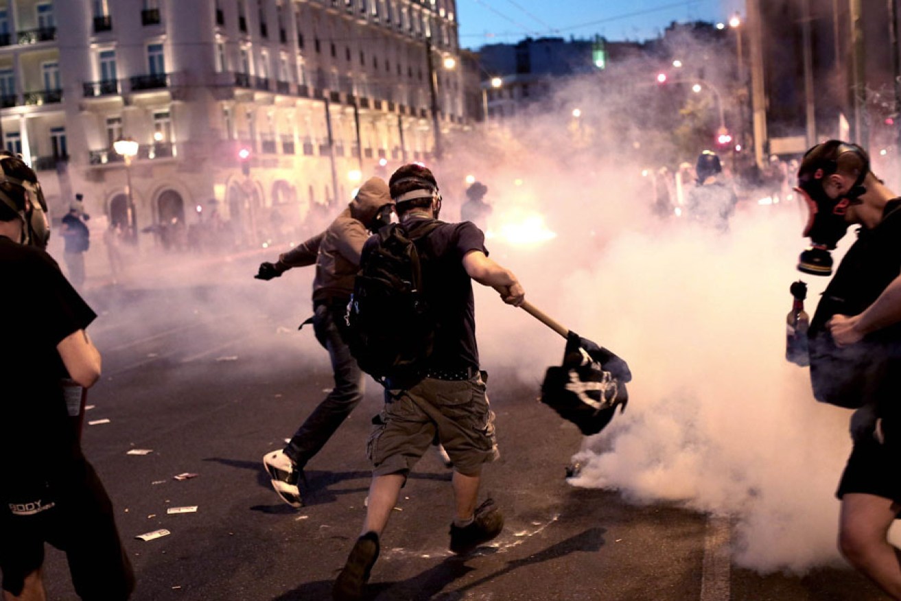 Anti-austerity protesters clash with riot police in front of the Greek Parliament in Athens.