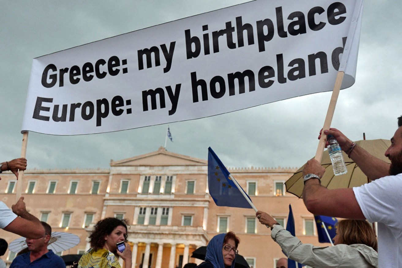 Protesters hold a banner while participating in a pro-euro demonstration in front of the parliament building in Athens.