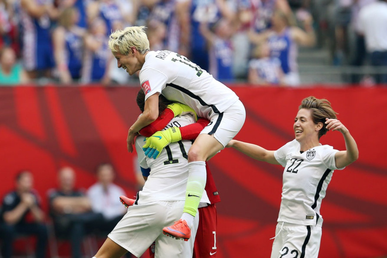 Carli Lloyd (wearing number 10) is mobbed by teammates after scoring a hat-trick.