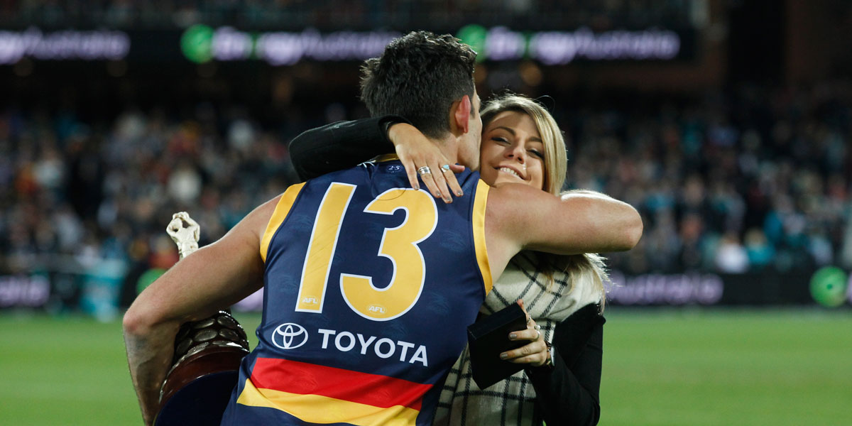 Crows captain Taylor Walker embraces Phil Walsh's daughter Quinn after the game. AAP image