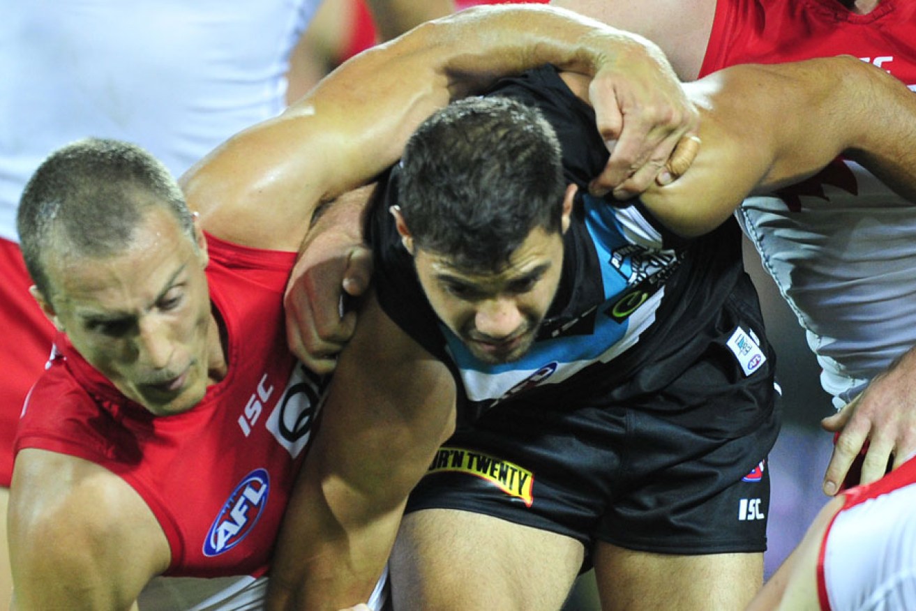 Paddy Ryder tussles with Swans backman Ted Richards during a match in Adelaide in April.