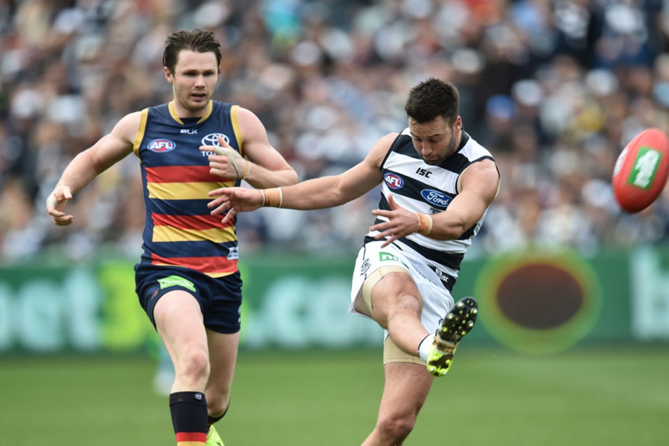 Adelaide's Patrick Dangerfield fails to prevent Jimmy Bartel getting his kick away. AAP image