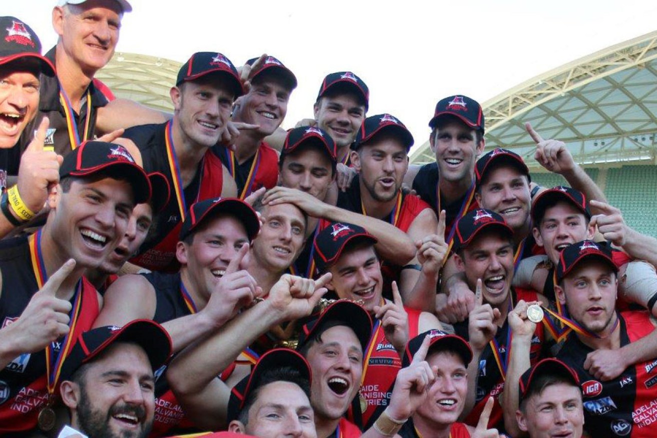 The victorious West Adelaide team with coach Mark Mickan (top, second from left). Photo: Peter Argent