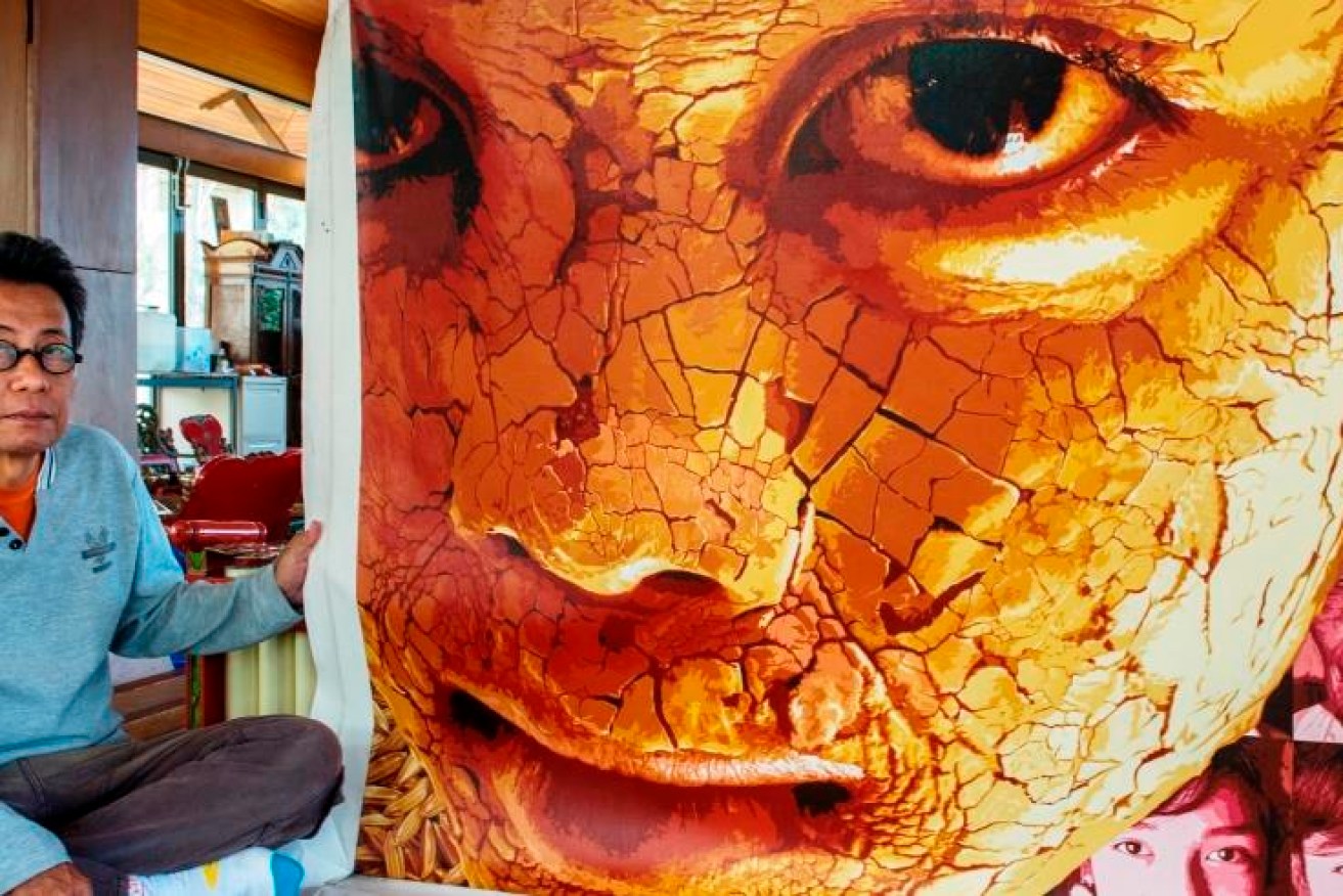 Indonesian community artist Moelyono, pictured this week at the Pendopo Javanese cultural pavilion at Flinders University, Bedford Park, with one of his eye-catching portraits.  