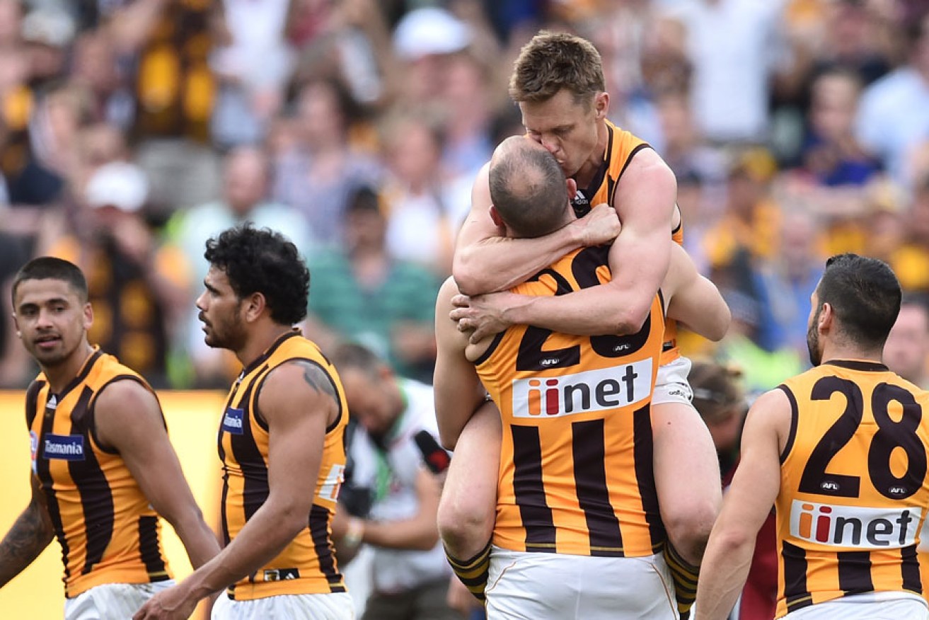 Ruckman David Hale (number 20) gets a hug from Sam Mitchell after the Hawks' premiership win on Saturday. AAP image
