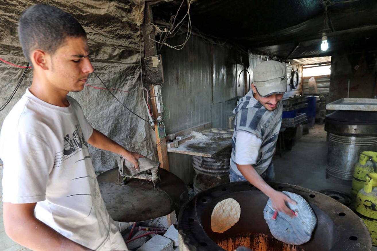 Syrian refugees bake bread at their shop in the Zatari Syrian Refugee Camp in Jordan.