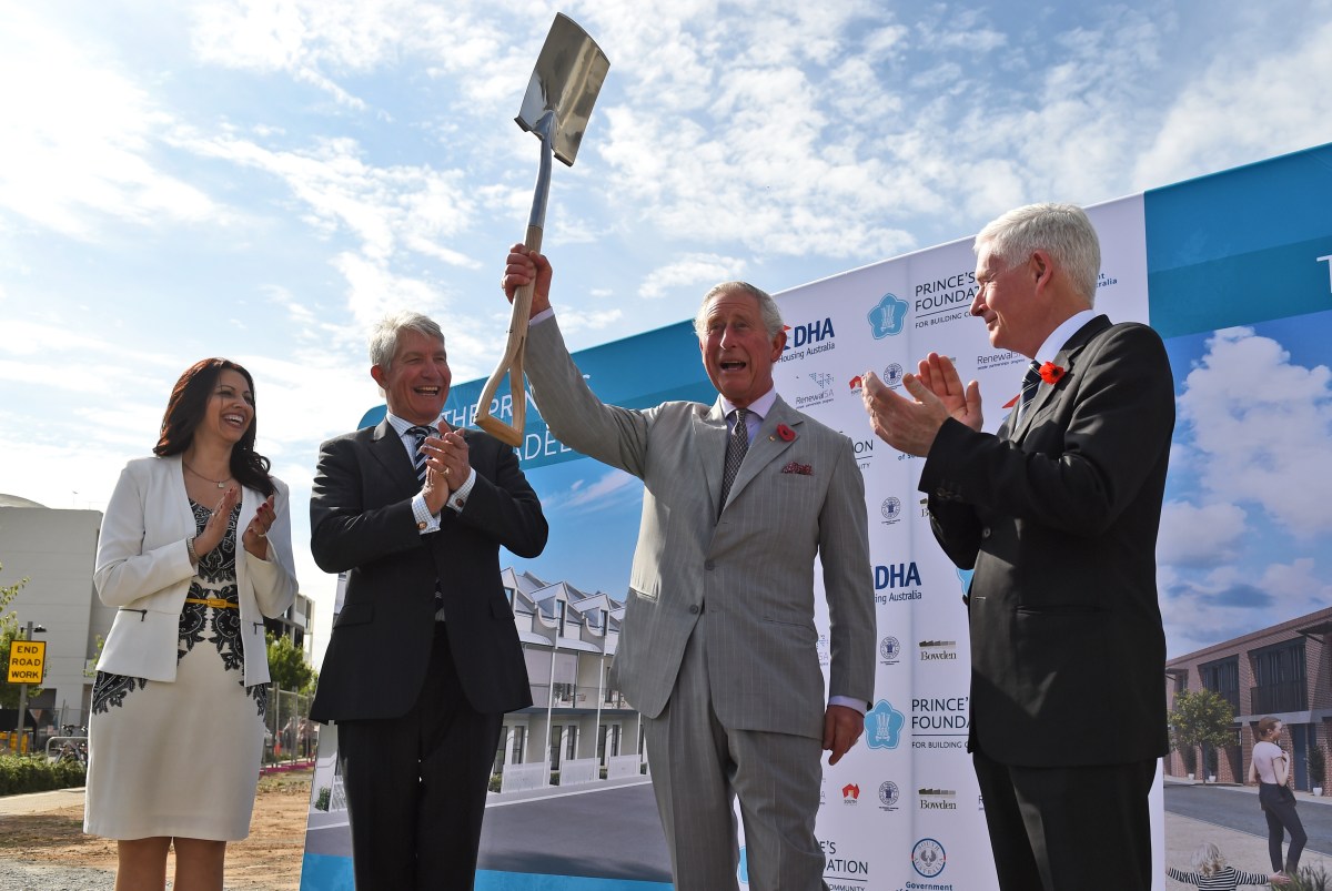Britain's Prince Charles (2/R) raises the spade after turning the first sod during a visit to the Bowden precinct, a sustainable urban development in Adelaide on November 10, 2015. Prince Charles and his wife Camilla are on a two-week tour of New Zealand and Australia. (AAP Image/AFP Pool, William West) NO ARCHIVING