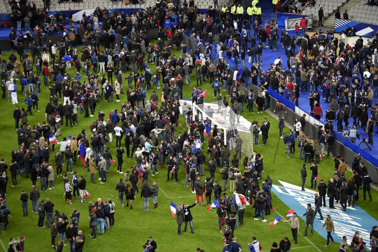 Football fans gather in the field as they wait for security clearance to leave the Stade de France in Saint-Denis, north of Paris, after locations near the France vs Germany friendly football match were targeted.